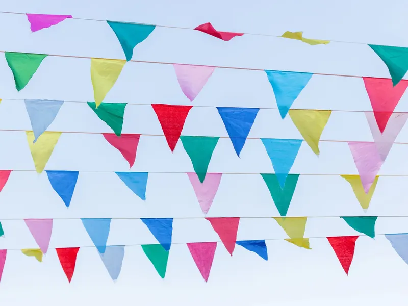 Guirlande de fanions colorés au-dessus d'une rue commerçante